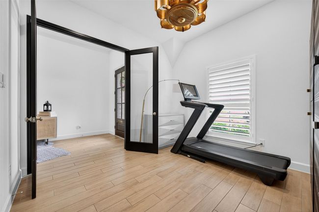 This flexible room features double glass doors and front-facing window with shutters, creating a bright, private space perfect for work or wellness. Located just off the entry, it offers convenience and separation from main living areas. | Image 21