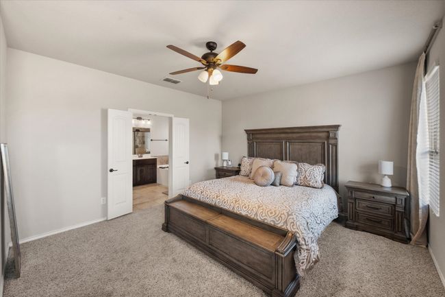 Bedroom featuring light carpet, visible vents, baseboards, and ceiling fan | Image 24