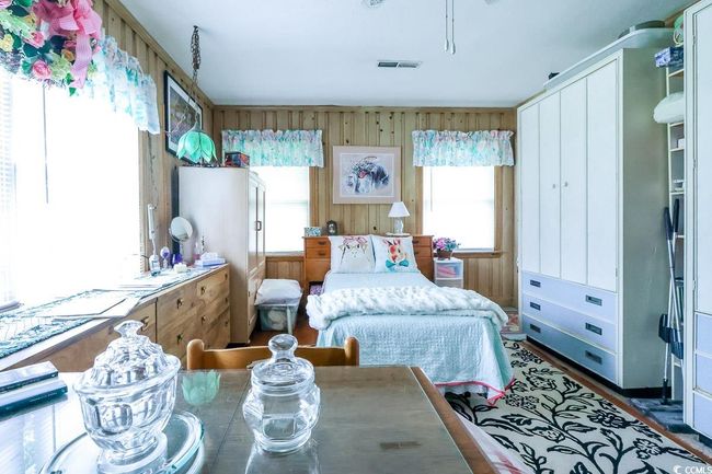 Bedroom with multiple windows and wood walls | Image 18