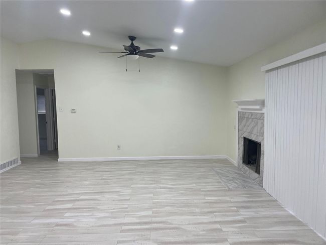 Unfurnished living room featuring ceiling fan, light wood-style flooring, recessed lighting, a fireplace, and baseboards | Image 21