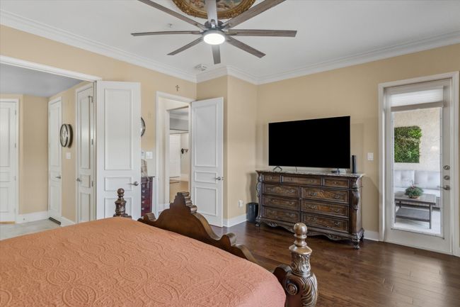 Bedroom featuring wood finished floors, ornamental molding, baseboards, and a ceiling fan | Image 12
