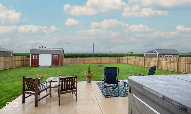 Back patio with a fenced backyard, a storage barn/shed, and hot tub | Image 18