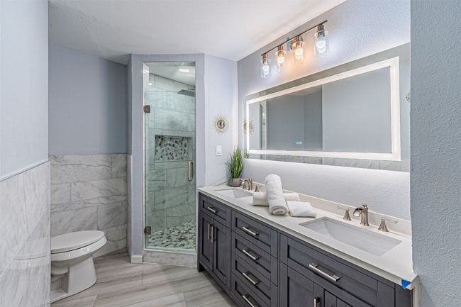 Bathroom featuring toilet, a shower stall, and a sink | Image 13