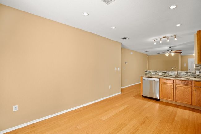 Kitchen with dishwasher, a sink, light wood-type flooring, decorative backsplash, and a ceiling fan | Image 10