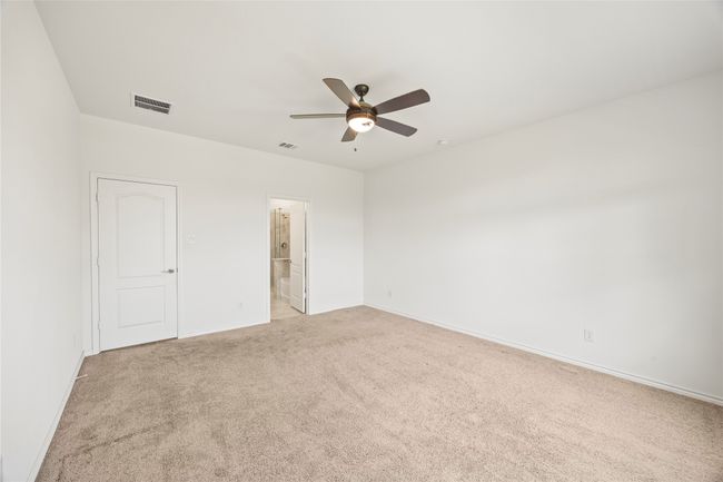 Unfurnished bedroom featuring light colored carpet, baseboards, a ceiling fan, and ensuite bathroom | Image 20
