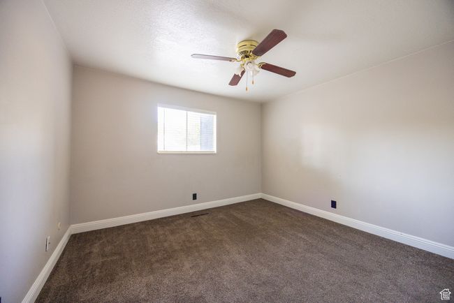 Empty room with dark carpet and a ceiling fan | Image 7