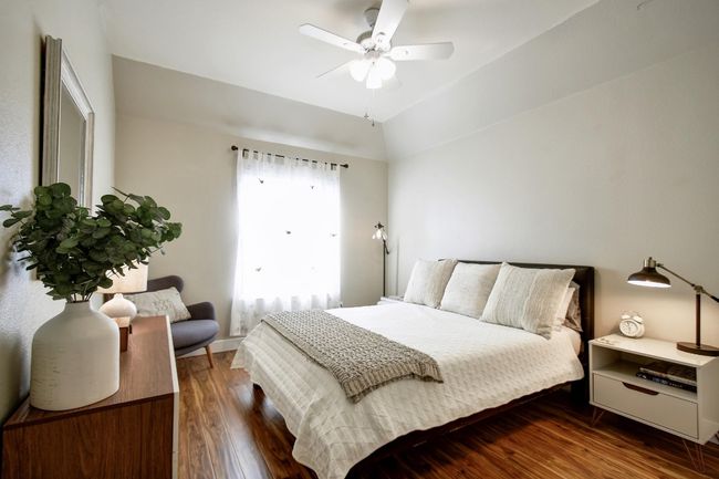 High ceilings, wood flooring, and a ceiling fan in this bedroom. | Image 22