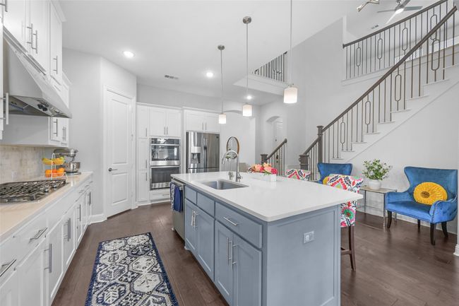 Kitchen with white cabinets, appliances with stainless steel finishes, dark wood-style flooring, and a sink | Image 9