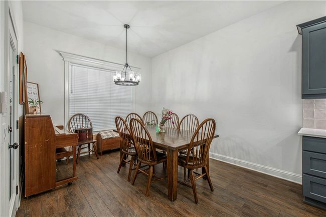Dining area featuring a notable chandelier, baseboards, and wood finished floors | Image 8