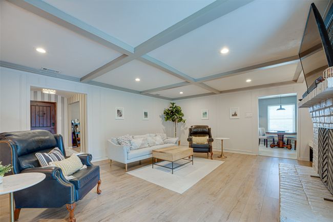 Living room featuring light wood finished floors, beam ceiling, a decorative wall, and recessed lighting | Image 8