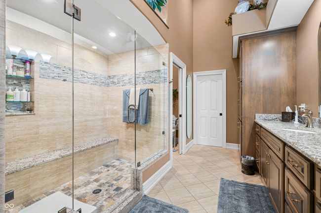 bathroom with a stall shower, baseboards, tile patterned floors, and vanity | Image 46