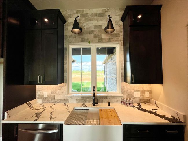 Apron sink with a beautiful view, brick walls, lighted glass uppers and under lighting. | Image 9