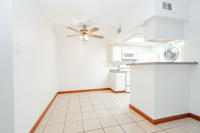Kitchen featuring visible vents, light countertops, white appliances, and ceiling fan | Image 4
