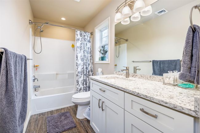 Full bathroom with shower / bath combo, wood finished floors, vanity, toilet, and visible vents | Image 17