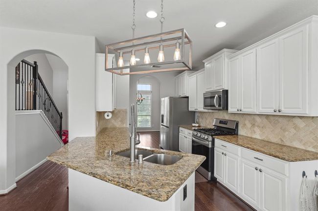 Host your next dinner party with confidence! This masterfully-equipped kitchen features a kitchen island, an abundance of cabinetry and hardware, TONS of counter space, granite countertops and stainless-steel appliances. | Image 6