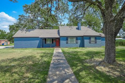 The front view of this lovely 3-bedroom, 3-bath home plus office highlights its classic farmhouse architecture and recently updated exterior. The home is perfectly situated to enjoy all the amenities of Hempstead, offering both comfort and convenience to its residents. | Image 2