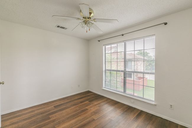 Spare room featuring dark wood finished floors, baseboards, ceiling fan, and a textured ceiling | Image 20
