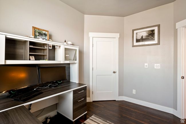 Office space with built in study area, dark wood-style flooring, and baseboards | Image 46