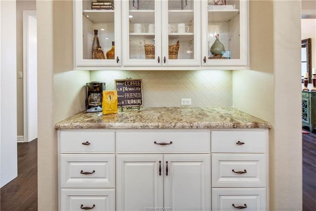 Bar with tasteful backsplash, a bar, and dark wood-style flooring | Image 13