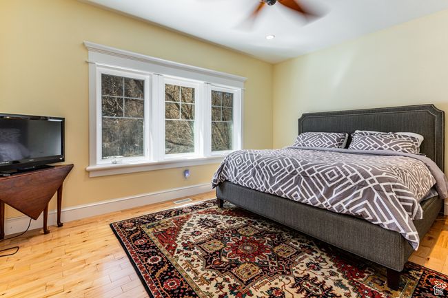 Bedroom with wood finished floors, baseboards, visible vents, ceiling fan, and recessed lighting | Image 15