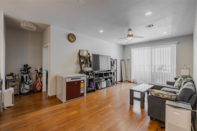 Living room with light wood-type flooring, a ceiling fan, and recessed lighting | Image 10