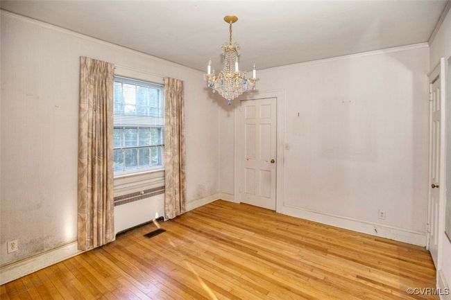 Spare room featuring a chandelier, crown molding, radiator, and light wood finished floors | Image 4