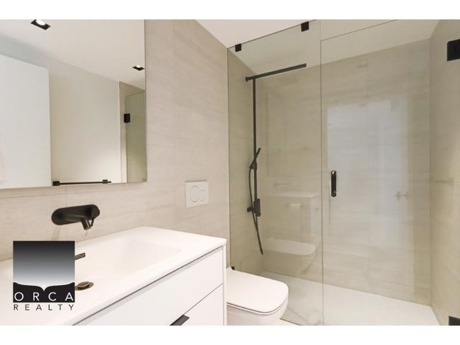 Full bath featuring vanity, a stall shower, and tile walls | Image 9