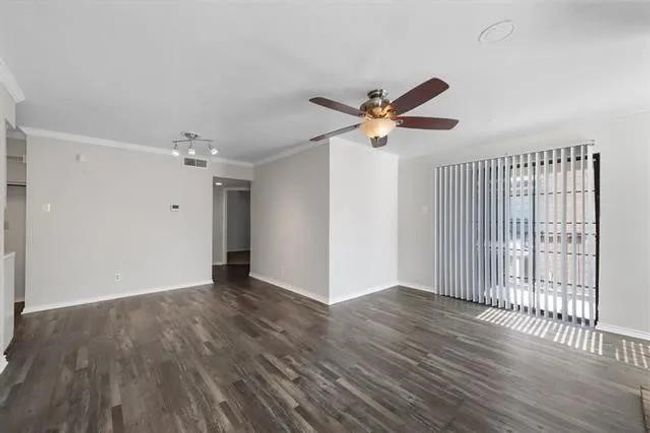 Unfurnished living room with wood finished floors, ceiling fan, and ornamental molding | Image 4