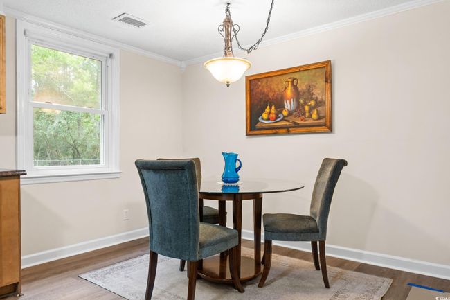 Dining area with wood finished floors, baseboards, and ornamental molding | Image 23