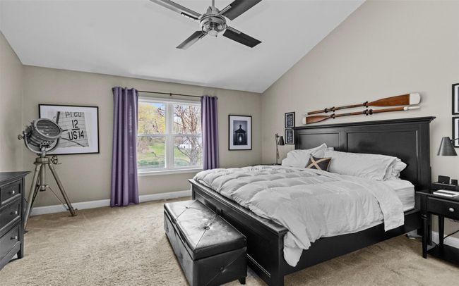 Bedroom featuring lofted ceiling, a ceiling fan, baseboards, and light colored carpet | Image 10