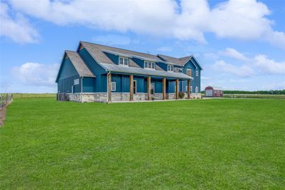 Craftsman-style home with a front lawn, an outdoor structure, and central AC | Image 3