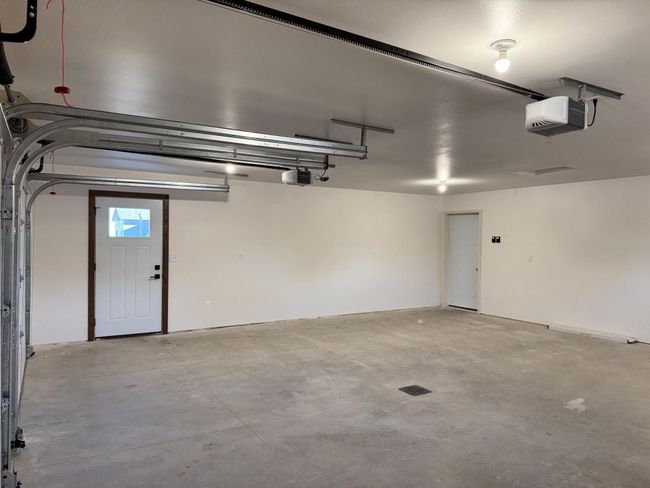 The finished garage includes floor drain and service door to front driveway area. | Image 23