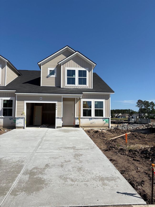 View of front of home featuring concrete driveway, board and batten siding, a shingled roof, and a garage | Image 12