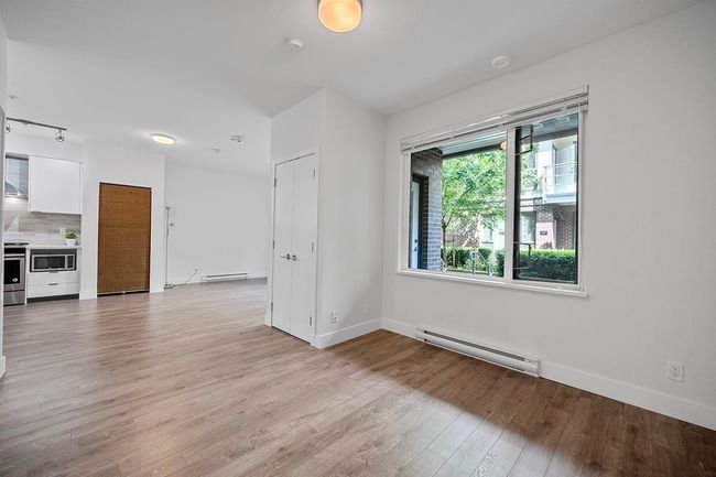 Empty room featuring baseboard heating, light wood-type flooring, and a smoke detector | Image 15