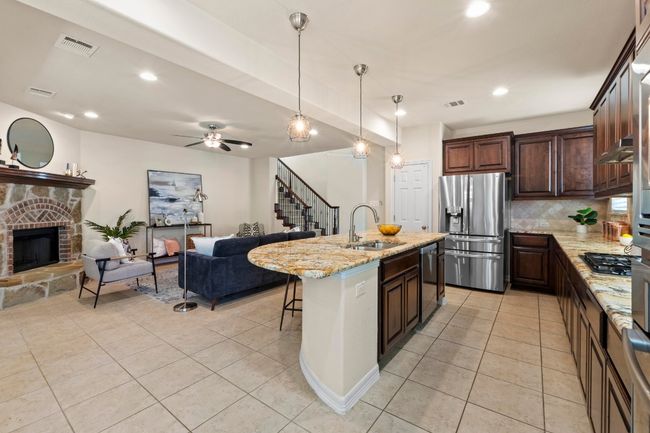 Kitchen featuring appliances with stainless steel finishes, open floor plan, light tile patterned flooring, decorative backsplash, and recessed lighting | Image 13