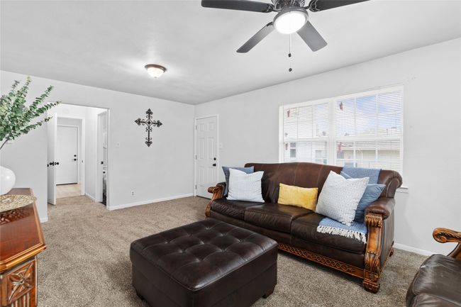 Carpeted living room with ceiling fan and baseboards | Image 19