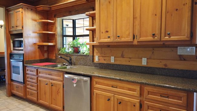 Kitchen with a sink, appliances with stainless steel finishes, open shelves, and dark countertops | Image 13