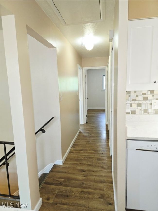 Corridor featuring dark wood-style flooring and attic access | Image 7