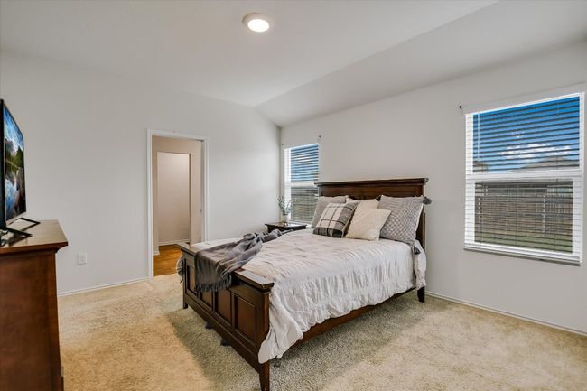 Bedroom with baseboards, carpet flooring, and lofted ceiling | Image 11