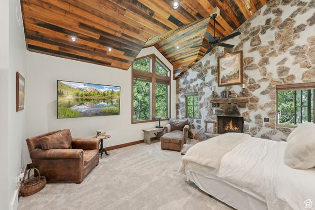 Carpeted bedroom with wood ceiling, high vaulted ceiling, and a stone fireplace | Image 17