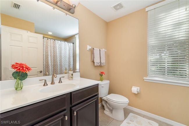 Bathroom with vanity, toilet, tile patterned flooring, and baseboards | Image 12