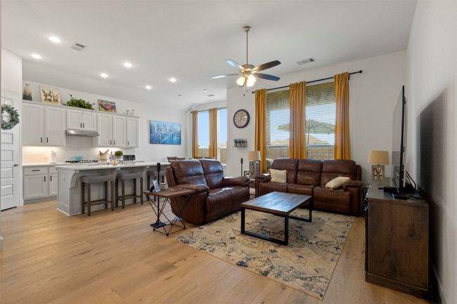 Living room with light wood-type flooring, a ceiling fan, and recessed lighting | Image 21