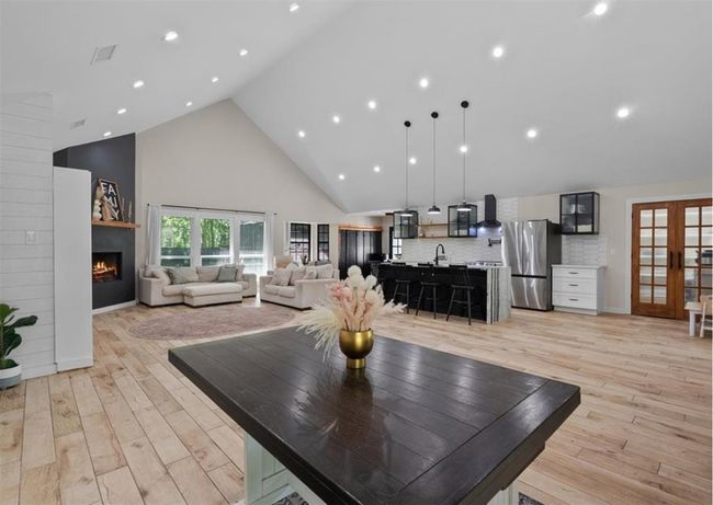 Showstopping vaulted ceiling with recessed lighting and seamless open-concept living, dining, and kitchen space. | Image 4