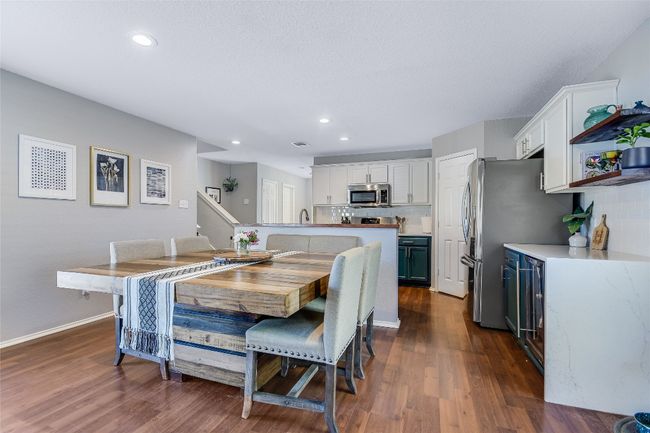Dining space with dark wood-style flooring, recessed lighting, and beverage cooler | Image 6