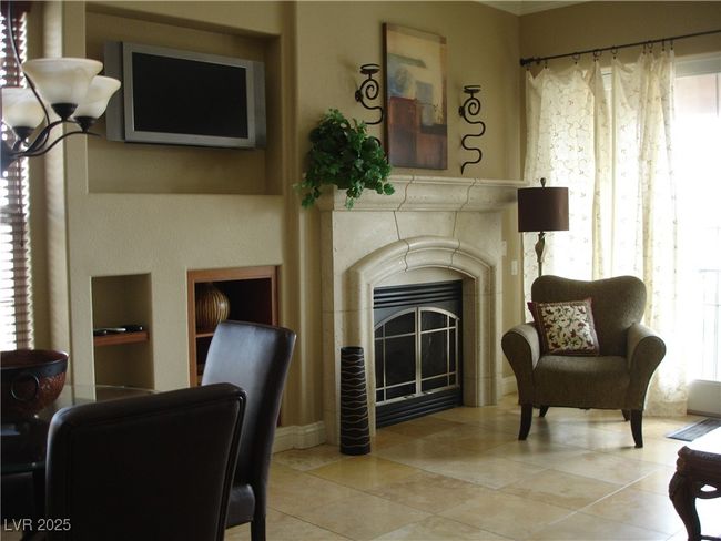 Living room with plenty of natural light, a fireplace, crown molding, and tile patterned flooring | Image 10