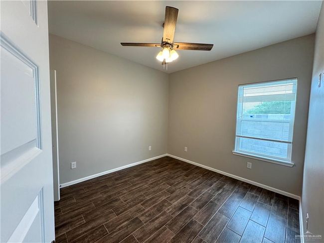 Unfurnished bedroom featuring dark wood-style floors, baseboards, a closet, and ceiling fan | Image 6