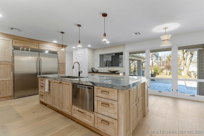 Main kitchen with luxury counters, luxury appliances, bar seating, and custom cabinets | Image 20