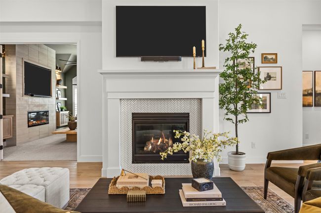 Living area with a tiled fireplace and wood finished floors | Image 16