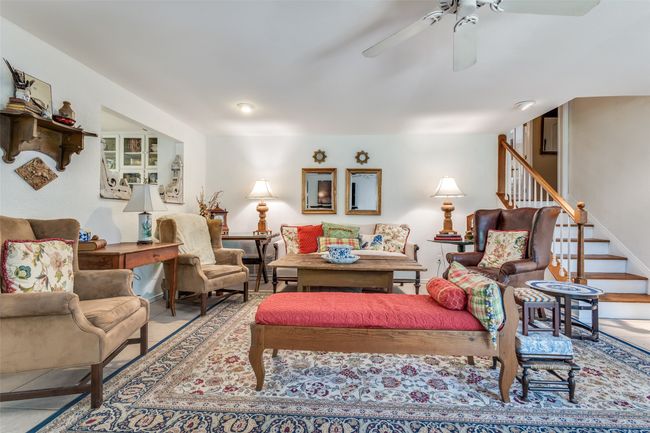 Living room with ceiling fan and stairs | Image 13