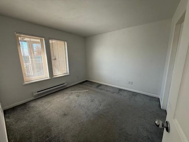 Carpeted empty room with baseboards and a baseboard heating unit | Image 8